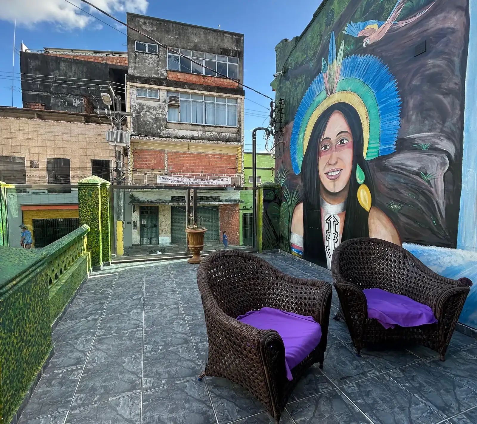 Terraço com poltronas e mural de mulher ribeirinha